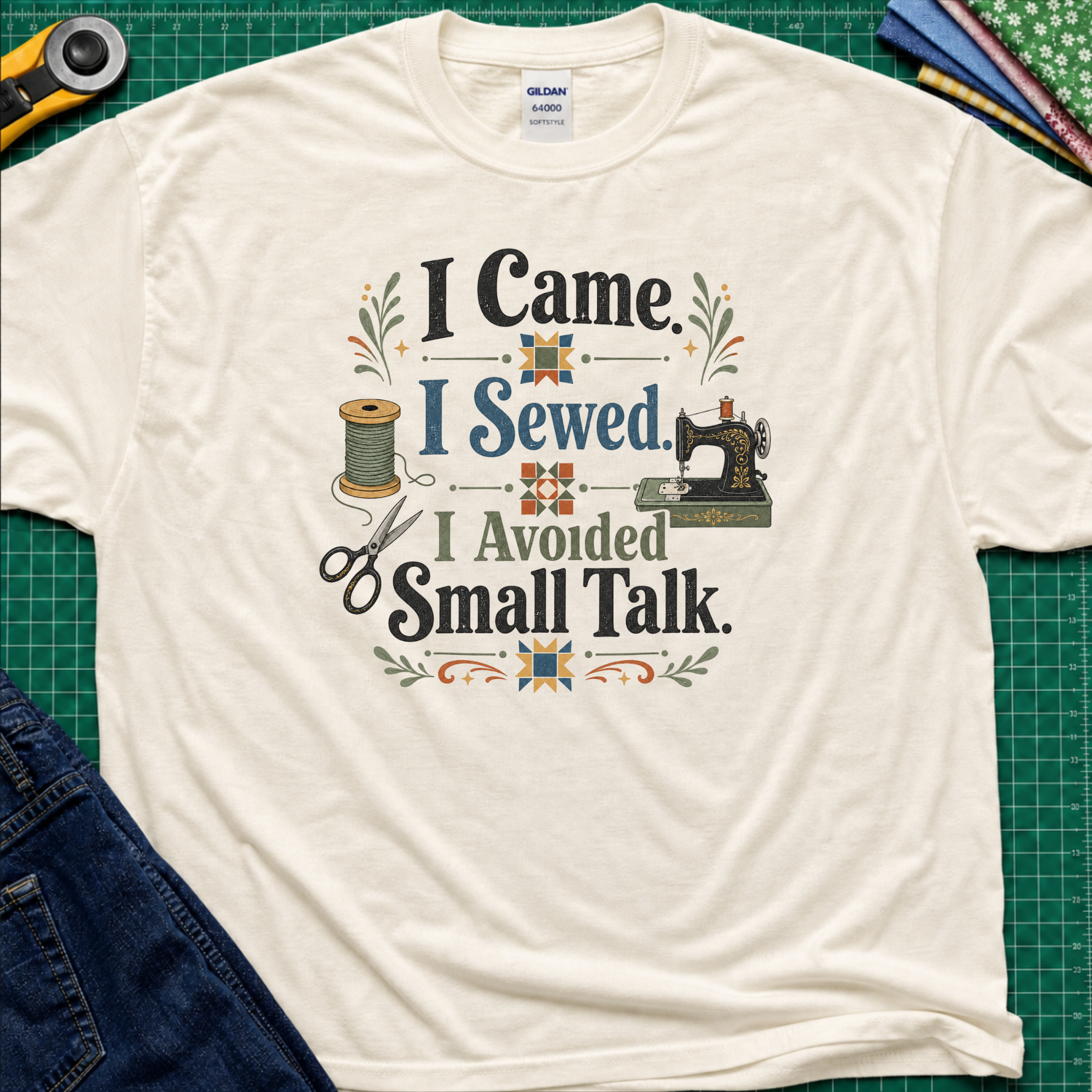 A light cream Gildan t-shirt with a retro-style sewing-themed graphic that reads 'I Came I Sewed. I Avoided Small Talk.
